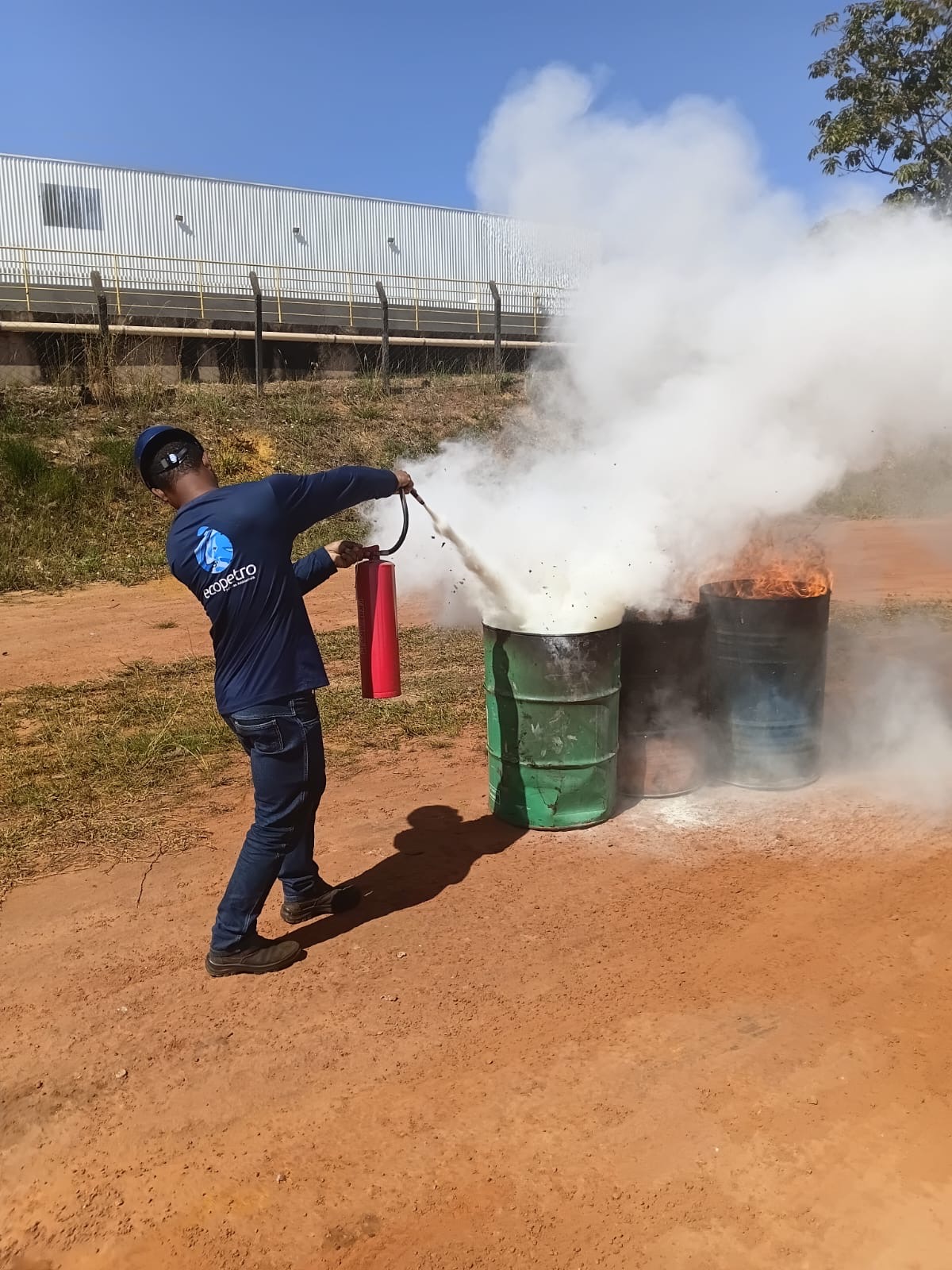 Colaborador executa combate a princípio de incêndio com uso de extintor